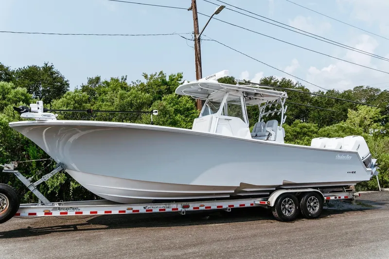 Slide: The Image of 2018 Onslow Bay 33 Tournament Edition boat on trailer, parked outdoors. - 13