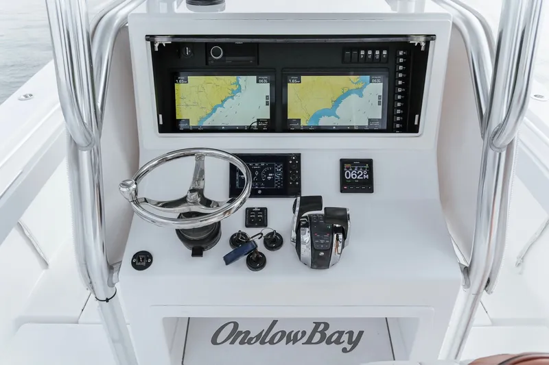 Slide: The Image of 2018 Onslow Bay 33 Tournament Edition boat dashboard with navigation screens and controls. - 14