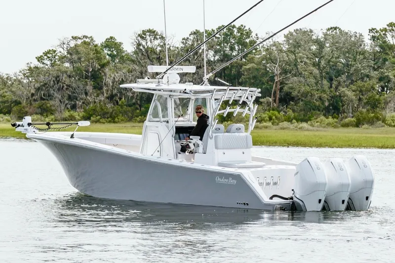 Slide: The Image of 2018 Onslow Bay 33 Tournament Edition boat on calm water, surrounded by lush greenery. - 7