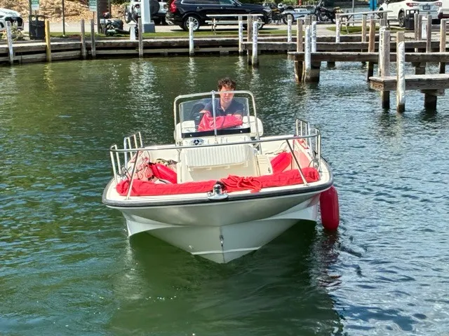 Slide: The Image of A 2007 Boston Whaler 170 Montauk on the water, featuring red fenders and cushions. - 3