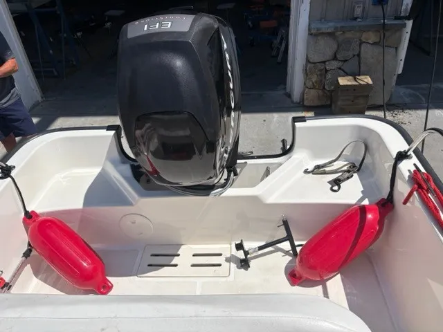 Slide: The Image of The image shows the stern of a Boston Whaler 170 Montauk with an outboard motor and red fenders. - 8