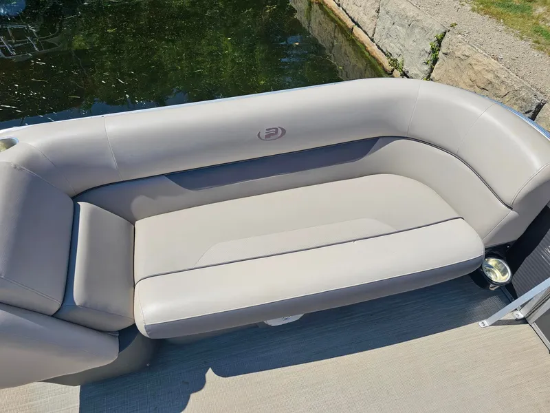 Slide: The Image of A sleek, gray seating sofa on a boat, surrounded by water and a stone wall. - 11