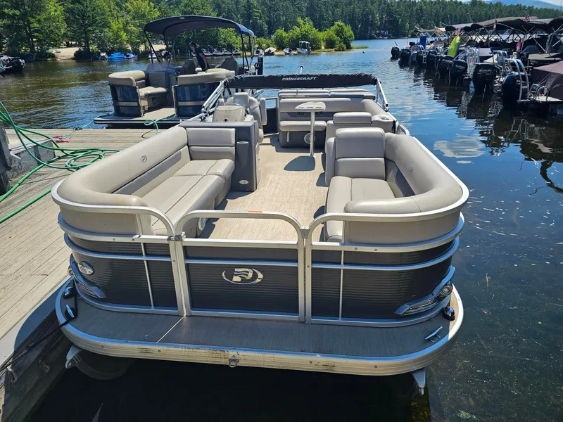 Slide: The Image of A 2019 Princecraft Vectra 21 pontoon boat docked. It features gray cushioned seating and a table. - 3