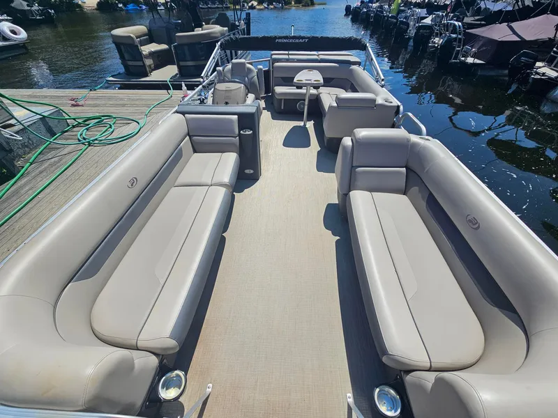 Slide: The Image of A 2019 Princecraft Vectra 21 pontoon boat with spacious seating areas and a table, docked. - 9