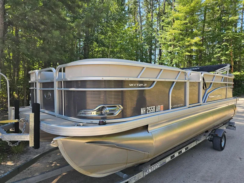 Slide: The Image of A 2019 Princecraft Vectra 21 pontoon boat on a trailer, surrounded by trees. - 4