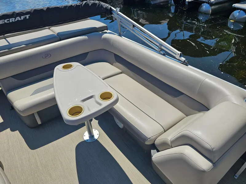 Slide: The Image of The image shows the seating area of a 2019 Princecraft Vectra 21 with a table and cup holders. - 7