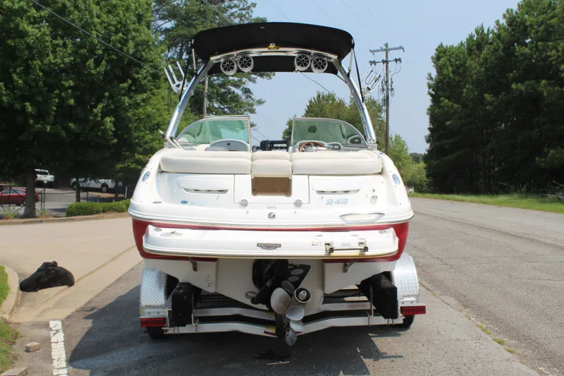 Slide: The Image of A 2007 Chaparral 246 SSi boat on a trailer on a street, surrounded by trees. - 5