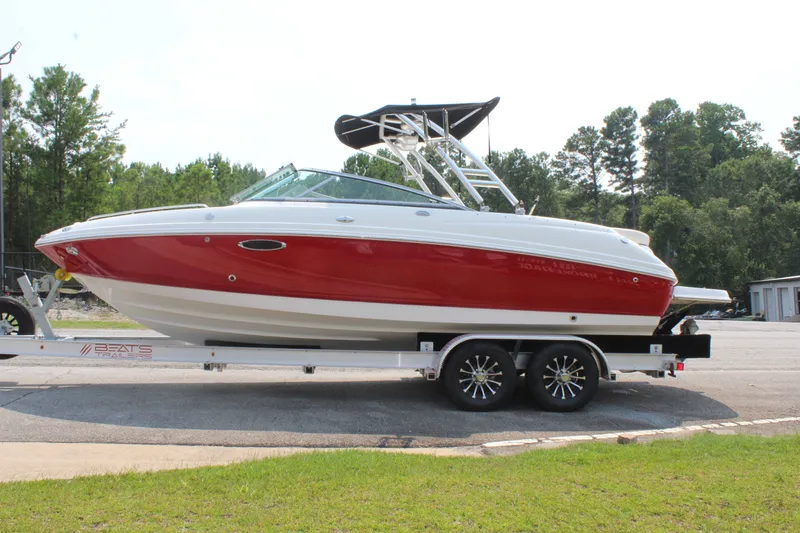 The Image of A red and white 2007 Chaparral 246 SSi boat on a trailer outdoors. - 1