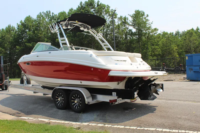 Slide: The Image of A red and white 2007 Chaparral 246 SSi boat on a trailer, surrounded by trees. - 3