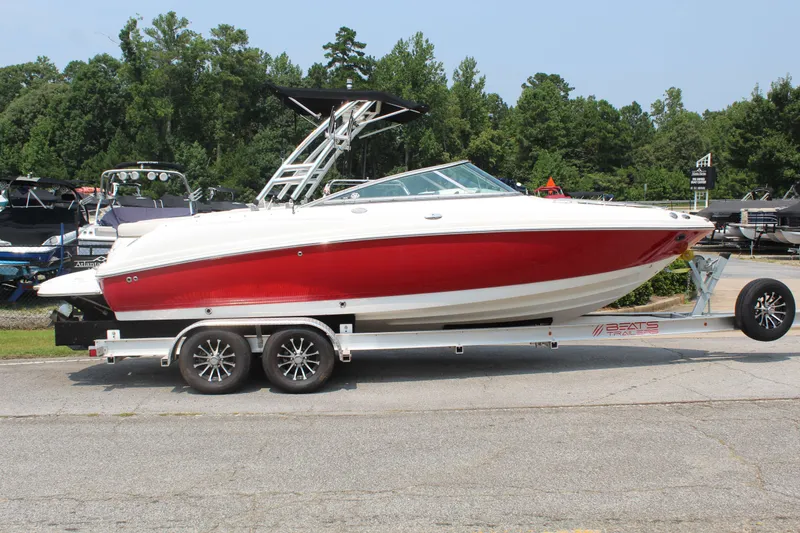 Slide: The Image of A red 2007 Chaparral 246 SSi boat on a trailer, surrounded by trees and other boats. - 6