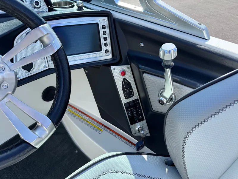 Slide: The Image of The image shows the cockpit of a 2016 MasterCraft X10 with a modern steering wheel and throttle. - 27