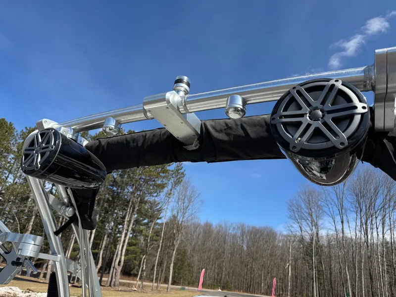 Slide: The Image of Close-up of a boat's wakeboard tower with speakers, surrounded by bare trees and blue sky. - 31