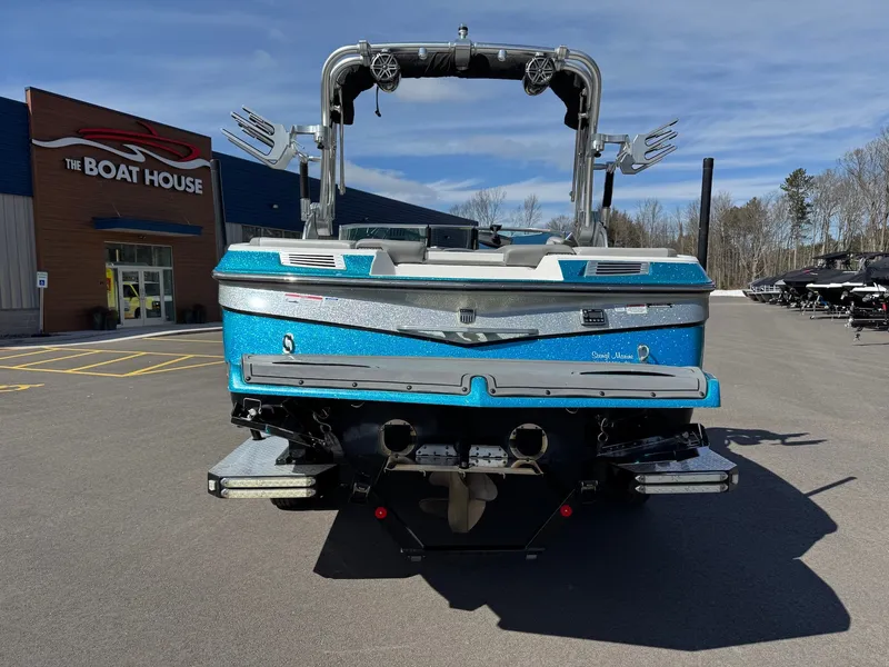 Slide: The Image of A blue 2016 MasterCraft X10 boat is parked in front of a building named "The Boat House." - 10