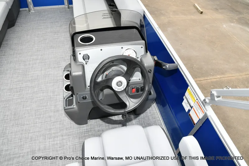 Slide: The Image of The image shows the helm of a Sun Tracker Party Barge 16 boat with gray flooring. - 7