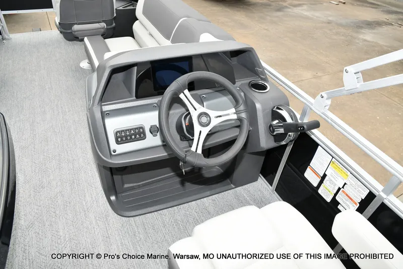 Slide: The Image of The image shows the helm of a 2027 Sun Tracker Fishin' Barge 20 DLX with a gray steering wheel. - 9