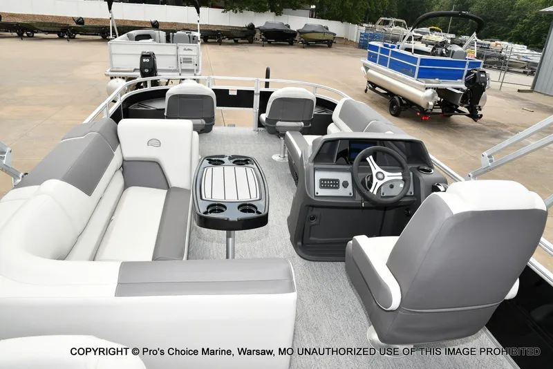 Slide: The Image of The image shows the interior of a 2027 Sun Tracker Fishin' Barge 20 DLX with gray seating and a table. - 13