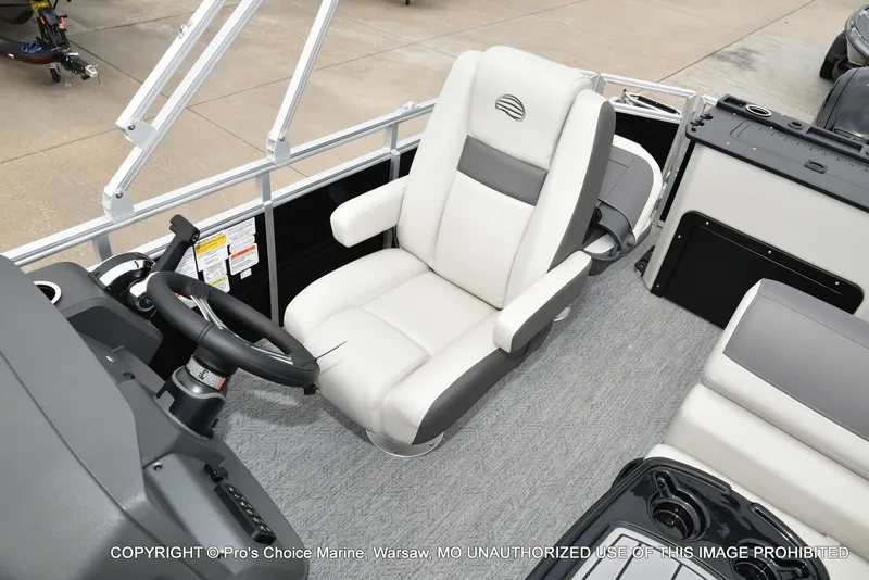 Slide: The Image of The image shows the helm of a 2027 Sun Tracker Fishin' Barge 20 DLX with a comfortable captain's chair. - 7