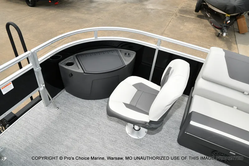 Slide: The Image of The image shows the cockpit of a 2027 Sun Tracker Fishin' Barge 20 DLX with a comfortable seat and helm console. - 4