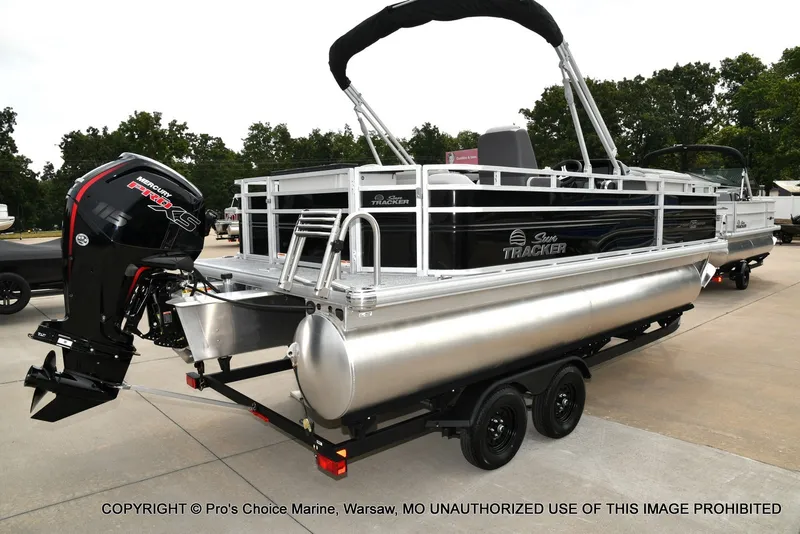 Slide: The Image of A 2027 Sun Tracker Fishin' Barge 20 DLX on a trailer, featuring an outboard motor. - 17