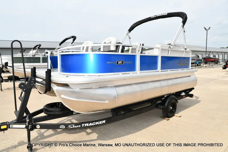 Slide: The Image of A 2027 Sun Tracker Bass Buggy 16 XL Select on a trailer, featuring a blue hull and bimini top. - 14