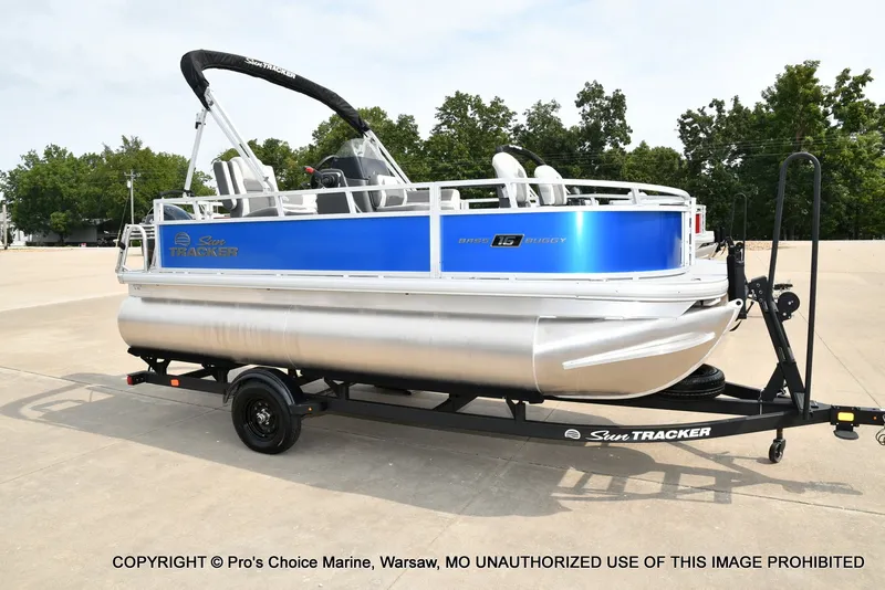 Slide: The Image of A Sun Tracker Bass Buggy 16 XL Select pontoon boat on a trailer, ready for transport. - 16