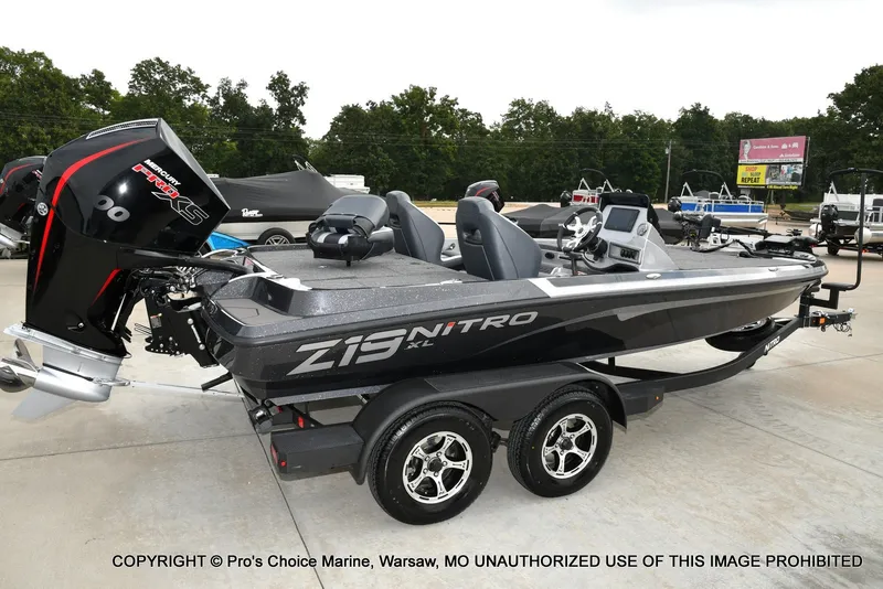Slide: The Image of A modern Nitro Z19 XL Pro bass boat with a powerful outboard motor, parked on a trailer. - 4