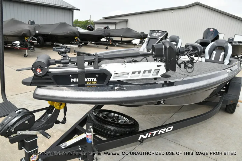 Slide: The Image of A Nitro Z19 XL Pro boat on a trailer, parked on a concrete lot in front of a building. - 8
