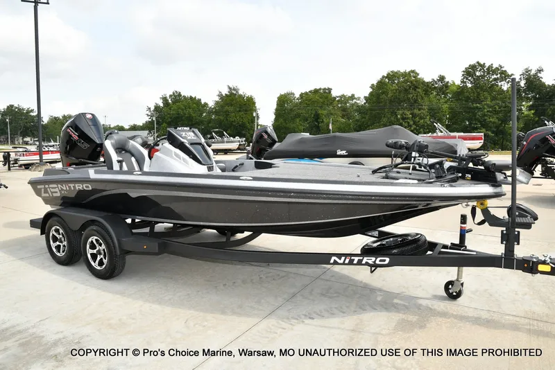 Slide: The Image of A black Nitro Z19 XL Pro boat from 2027 on a trailer, parked on a concrete lot. - 2