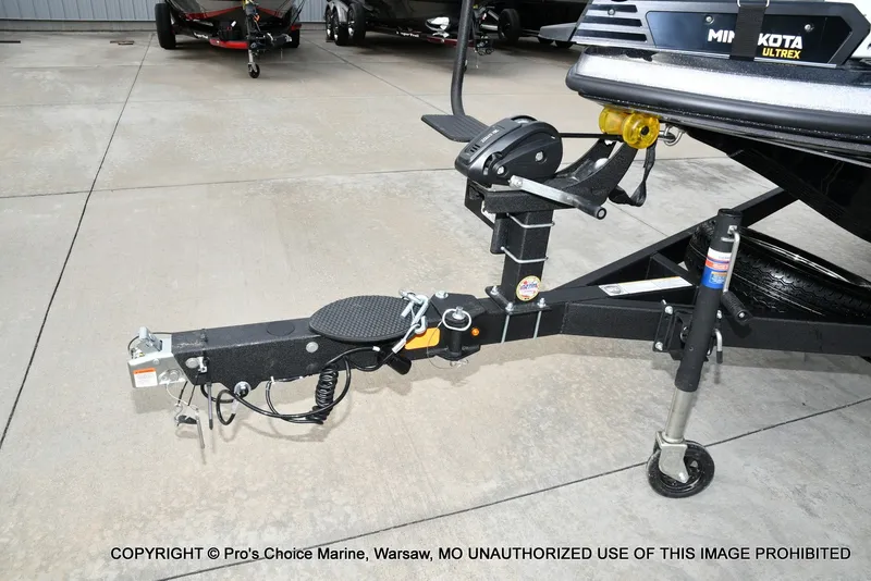 Slide: The Image of A boat trailer with a black frame and electrical connections, parked on a concrete floor. - 34