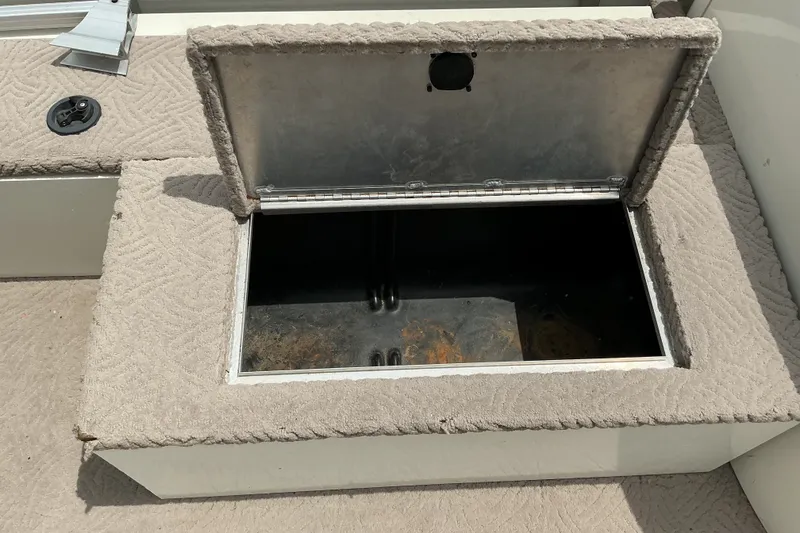 Slide: The Image of Open storage compartment on a 2003 Lowe Trinidad 220 boat, featuring carpeted interior. - 14