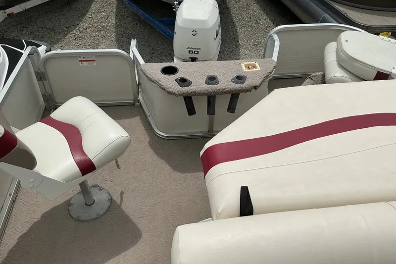 Slide: The Image of 2003 Lowe Trinidad 220 boat interior with white and red seating, cup holders, and Johnson motor. - 10