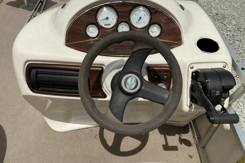 Slide: The Image of Steering console of a 2003 Lowe Trinidad 220 boat with gauges and controls. - 13