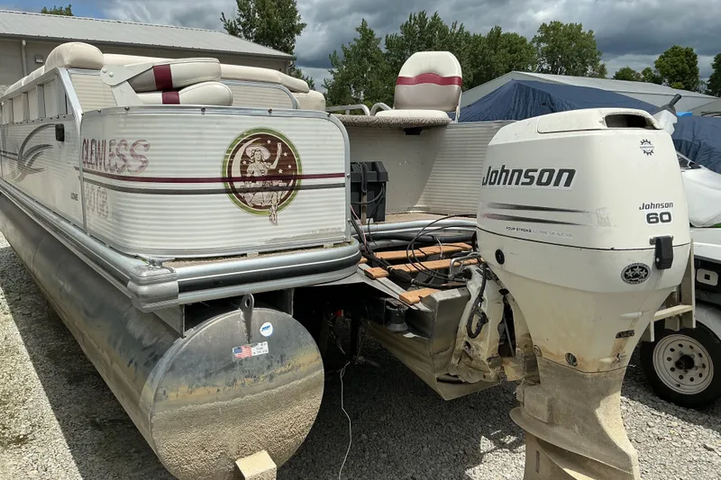 Slide: The Image of 2003 Lowe Trinidad 220 pontoon boat with Johnson 60 outboard motor, parked outdoors. - 3