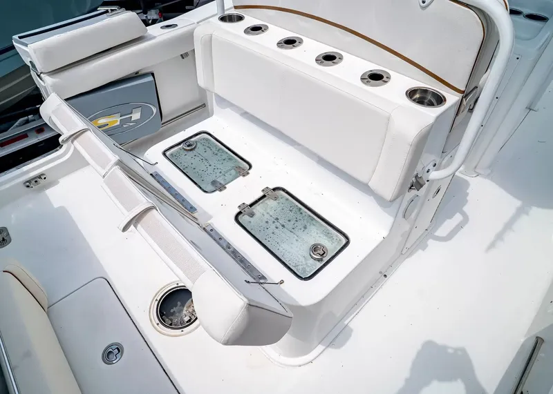 Slide: The Image of The image shows the cockpit of a 2020 Sea Hunt Gamefish 27CB with white upholstery and cup holders. - 13