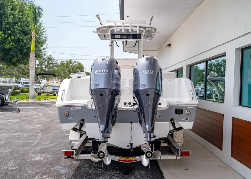 Slide: The Image of A 2020 Sea Hunt Gamefish 27CB with twin outboard engines, parked beside a building. - 3