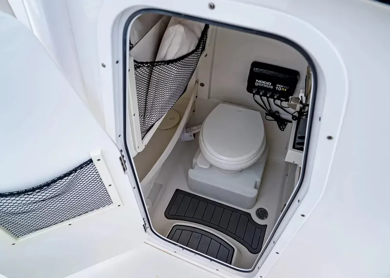 Slide: The Image of The image shows a compact boat toilet with netted storage pockets and an electronic control panel. - 24