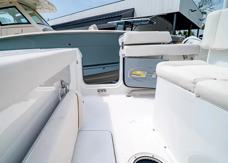 Slide: The Image of The image shows the cockpit of a 2020 Sea Hunt Gamefish 27CB with white upholstery. - 14