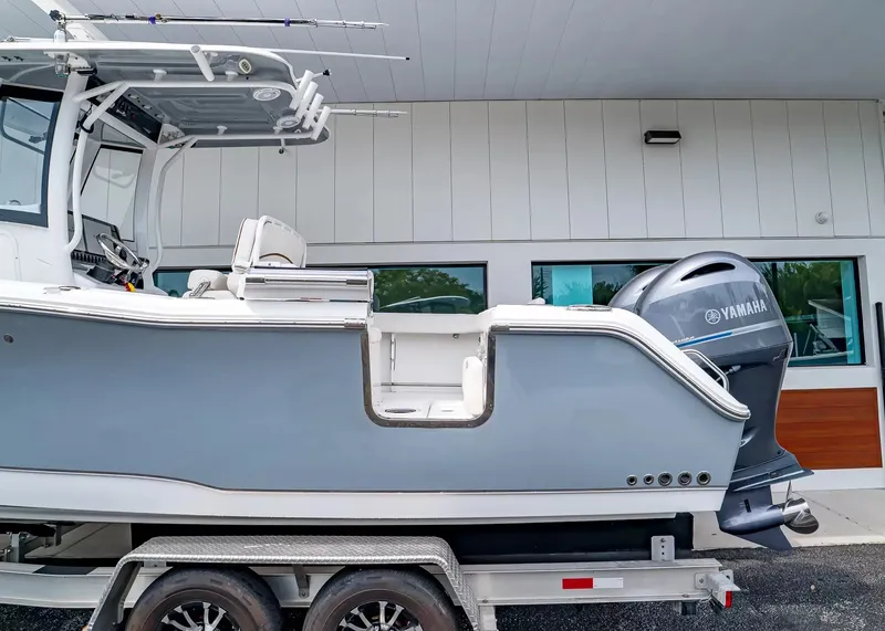 Slide: The Image of A 2020 Sea Hunt Gamefish 27CB on a trailer, featuring a Yamaha outboard motor. - 5