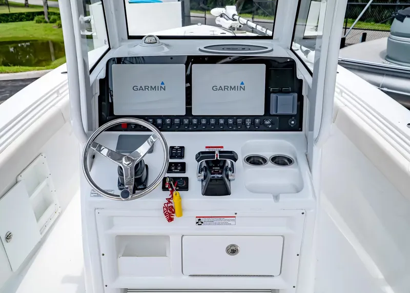 Slide: The Image of The image shows the helm of a Sea Hunt Gamefish 27CB boat with Garmin screens. - 18