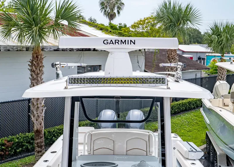 Slide: The Image of A 2020 Sea Hunt Gamefish 27CB with Garmin equipment, surrounded by palm trees. - 29
