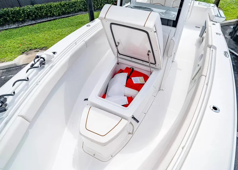 Slide: The Image of The image shows the open storage compartment of a Sea Hunt Gamefish 27CB boat with life jackets. - 31