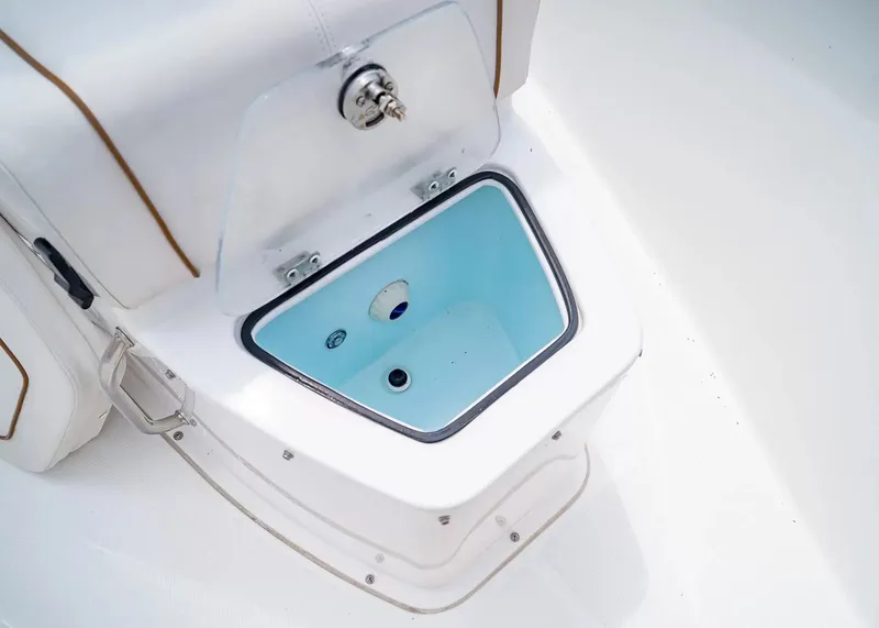 Slide: The Image of An open storage compartment on a 2020 Sea Hunt Gamefish 27CB boat, featuring a blue interior. - 32