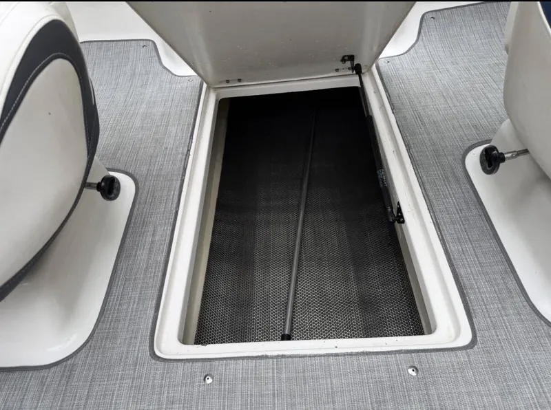 Slide: The Image of An open storage compartment in the floor of a 2020 Chaparral SSi 21 boat. - 10