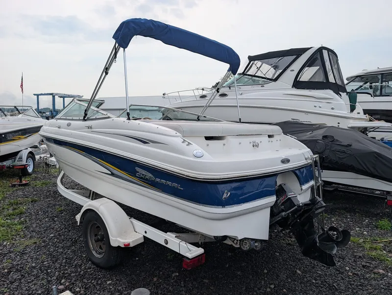 Slide: The Image of A 2002 Chaparral 183 SSE boat on a trailer. It features a blue canopy. - 5