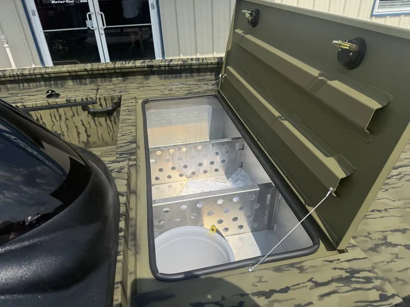 Slide: The Image of An open storage compartment on a Lowe Outlet 20-CATFISH boat, featuring perforated metal dividers. - 2