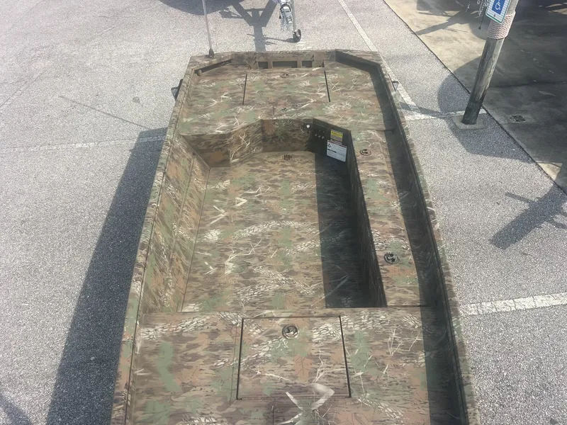 Slide: The Image of A rugged boat with camouflage pattern, suitable for hunting or fishing, is parked on a lot. - 6