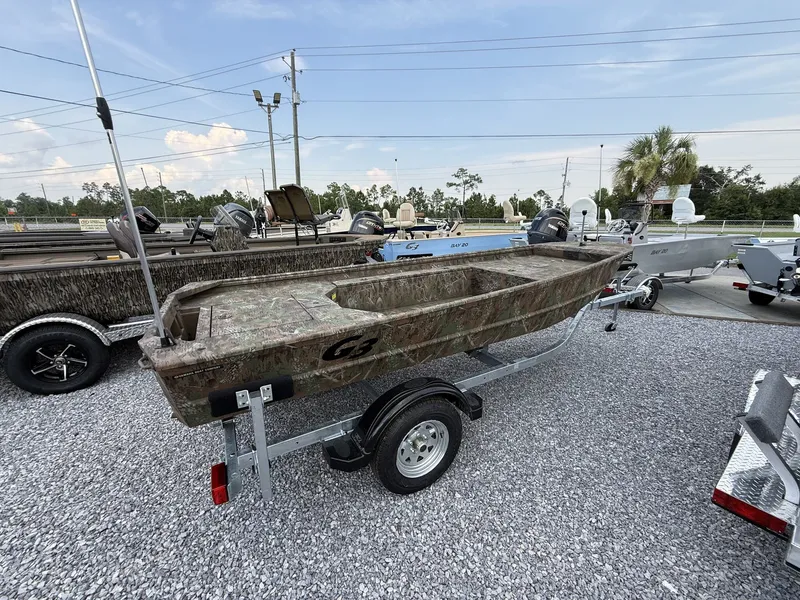 Slide: The Image of A G3 Gator Tough 15DK-40HP YAMAHA boat on a trailer, surrounded by other boats and trees. - 9