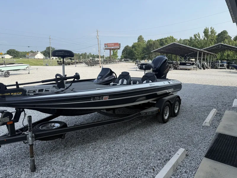 Slide: The Image of A 2018 Skeeter ZX200 bass boat on a trailer in a gravel lot. - 3