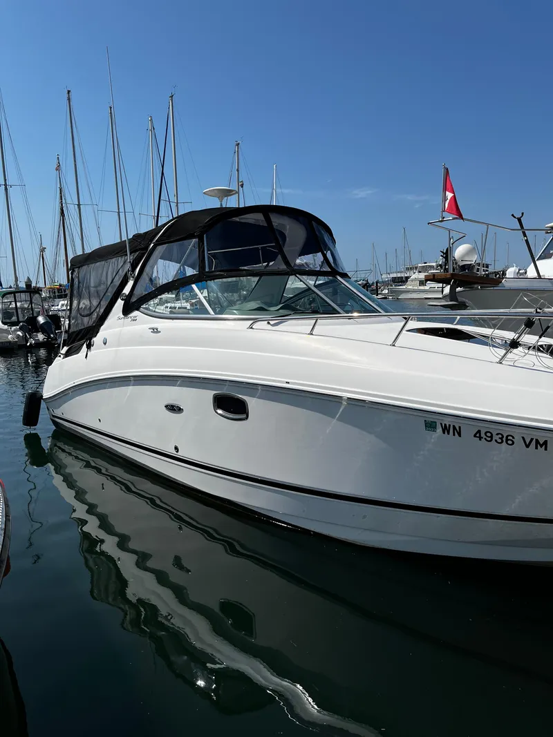 Slide: The Image of A 2013 Sea Ray Sundancer 280 docked in a marina. It features a black canopy. - 2