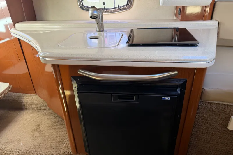 Slide: The Image of Compact kitchenette in 2013 Sea Ray Sundancer 280 with sink and mini fridge. - 29